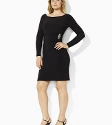 This sleek dress is tailored with an elegant boat neckline, shirring at the left waist and an encrusted broach exuding a chic, sophisticated style.