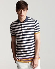 This inventive Burberry polo features a contrasting colored stripe at the hem, infusing unique appeal into a classic garment.