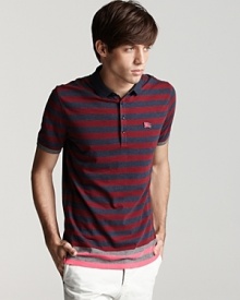 This inventive Burberry polo features a contrasting colored stripe at the hem, infusing unique appeal into a classic garment.