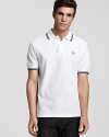 Widely known as the pioneer of Mod, British street fashion, Fred Perry polos have become an iconic fashion silhouette. A sporty polo with contrast double stripe trim and embroidered logo at left chest. Slim fit.