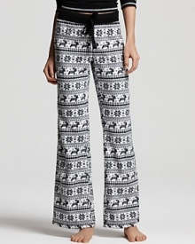 Winter theme pajama pants in a cozy fleece with snowflake and deer print all over.