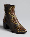 B Brian Atwood amps up this season's have-to-have-them booties with stand-out snake embossed uppers. Pointed toes and abbreviated heels give them Western kick.