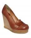 Lucky Brand's June wedge pumps literally elevate the look of a traditional loafer. Made in leather with a round-toe silhouette, they feature a trendy stacked wedge heel and platform sole. Available in black or sequoia, a rich cognac color.