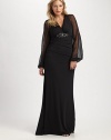 This stunning gown was designed to accentuate your shape, thanks to a striking embellishment at a subtly gathered bust and sheer sleeves offering glamorous arm coverage.V-necklineSheer, bell sleevesEmbellishment at gathered bustConcealed back zipperFully linedAbout 45 from natural waist95% polyester/5% spandexDry cleanMade in USA of imported fabric