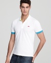 Dramatic pops of neon on the under-collar, croc logo and sleeve edge set this ultra-slim fitting Lacoste polo apart.