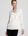 A dressed-up version of your classic white shirt, this Elie Tahari blouse flaunts a fluid necktie and contrast trim for modern elegance.