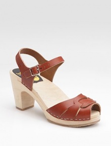 Feminine silhouette of soft leather with front strap design and staple trim.Wooden heel, 3 (75mm) Wooden platform, ½ (15mm) Compares to a 2½ heel (65mm) Peep toe Adjustable strap Leather lining Rubber sole Made in SwedenOUR FIT MODEL RECOMMENDS ordering true whole size; ½ sizes should order the next whole size up. 