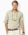 A trim-fitting military shirt in durable cotton twill channels rugged safari style with bold bellows pockets at the chest.