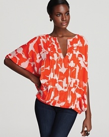 In a hot hue, DIANE von FURSTENBERG's bright blouse shines in a dolman silhouette and a flowering abstract floral print.