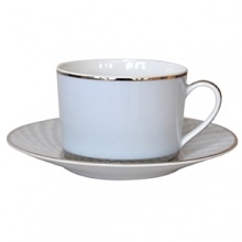 Carefully rendered in a style reminiscent of neoclassic trompe l'oeil-a French term for artwork that depicts optical illusions-a captivating geometric rosette motif traverses this elegant porcelain tea cup from Bernardaud. Delicate shades of ice blue, mother-of-pearl and gray are enhanced by a fine platinum trim and central medallion design.