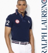 A trim-fitting short-sleeved polo shirt is rendered in breathable cotton mesh with bold country embroidery, celebrating Team USA's participation in the 2012 Paralympic Games.