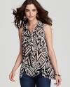 Make a statement this season in a GUESS sleeveless button-up top, imbued with a boldly eclectic print.