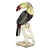 An amazing replica of a beautiful tropical bird is this toucan in faceted Black Diamond crystal with accents in Light Siam and Light Topaz crystal. It has eyes in Erinite crystal. Its trademark bill is in Green Beryll with Topaz and Peacock Blue crystal. Perched peacefully on a maple wood stand, set him up as an interiors highlight.