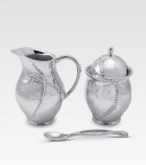 A handmade creamer and sugar set in hammered, sandcast aluminum, buffed by hand for unparalleled shine and elegance. Set includes sugar bowl with lid, creamer and matching spoon Creamer, 4½H X 3 diam. Sugar, 4½H X 3 diam. Spoon, 5 long Sandcast aluminum Food safe Hand wash Imported 