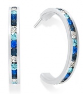 Traditions gives a sparkling boost to a simple pair of hoop earrings. A channel-set row of round-cut blue crystal with Swarovski elements shines within a sterling silver setting. Earrings feature a post and stud backing. Approximate diameter: 3/4 inch.