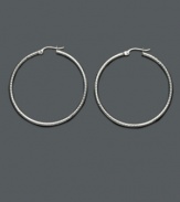 Add a playful touch to your look with fashionable hoops. These sterling silver hoop earrings feature a unique diamond-cut texture will never go out of style! Approximate diameter: 1-1/2 inches.