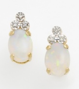 Showing off all the colors of the rainbow, a perfectly oval-cut opal takes center stage in these earrings. Accented with a triangle of round-cut diamonds on top and set in lustrous 14k gold.