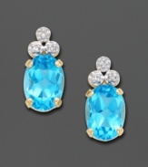 Simply elegant in design, these striking earrings feature three sparkling diamonds atop a gleaming blue topaz stone. Set in 14K gold. For pierced ears only.