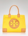 Make Tory Burch's signature coated canvas tote your day-to-day choice. Sized for the essentials, the brightly hued style adds polish to daytime denim and basics.