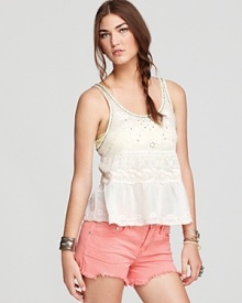 Beading and neon embroidery embellish an ivory cotton Free People tank flaunting a playful peplum--the whimsical addition to your summer wardrobe the balmy season is wanting for.