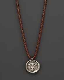 Silver Gucci charm on a braided brown natural leather necklace.