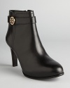 Tory Burch ups the style quotient on the basic bootie in these sleek shoes featuring almond toes, polished leather and elegant logo accents.