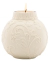 Embossed holly and scroll designs embellish this votive candle holder, perfect for adding a glow to your holiday table. From Lenox.