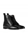 Luxurious boot in high-polished black calf leather - Stylish wingtip design inspired by classic mens footwear  - Features a narrow shape, rounded toe, thin laces to ankle, and a mini block heel - Favorite shoe with a pantsuit, knit skirt or skinny jeans