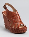 Woven and braided details lend unique appeal to a strappy wedge sandal from Frye.