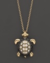 Black and white diamonds set in a 14K. yellow gold turtle pendant.