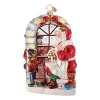 Santa crafts Christmas toys under the watchful eye of a nutcracker in this festive glass ornament.