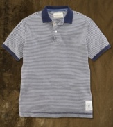 A preppy polo is transformed with weathered stripes and naval-inspired graphics for a vintage-inspired look that is ruggedly hip.