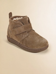 Comfort meets style in this ankle-high silhouette with sheepskin lining and a sturdy strap with grip-tape closure. Grip-tape closure Suede upper Rubber sole Padded insole Sheepskin lining Imported