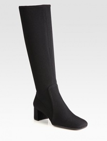 A tall silhouette of stretch fabric with a square toe and block heel. Self-covered heel, 1¾ (45mm)Shaft, 15Leg circumference, 13½Stretch-fabric upperSide zipRubber solePadded insoleImported