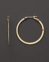 These flat 18K yellow gold hoops are a stunning take on a timeless classic. Set with a signature ruby accent.