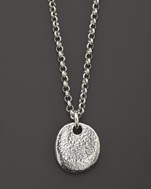 A hammered pebble of pure silver dangles from an elegant chain.