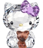 Cuter than ever, Hello Kitty cuddles her favorite teddy bear in this irresistible Swarovski crystal figurine. With printed whiskers and her trademark bow in sparkling violet.