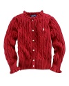 An essential cabled cotton sweater is adorned with a feminine ruffle trim at the neckline and cuffs.