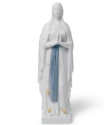 A soothing presence, Our Lady of Lourdes is draped in layers of beautiful white with a sash of blue about her waist, all in handcrafted Lladro porcelain.