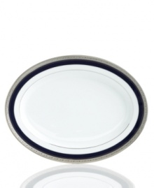 Formal white fine china displays a dramatic combination of scrolling leaves on shimmering platinum and an inner band of intense cobalt blue. Dishwasher safe.