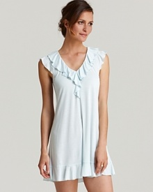 A solid flutter sleeve chemise with cascading ruffle trim along a V-neckline and hem.