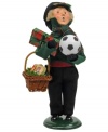 A young boy stocks up on treats and toys for a merry holiday, all while singing beloved holiday carols. An adorable figurine from the Bearing Gifts family, with the handcrafted charm of Byers' Choice.