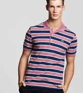 Dusty pink and navy stripes cover this slim fit short sleeve polo from Lacoste.