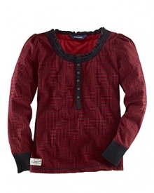 Traditional cotton check receives a girly makeover with a ruffle and lace trim along the neck and long puffed sleeves.