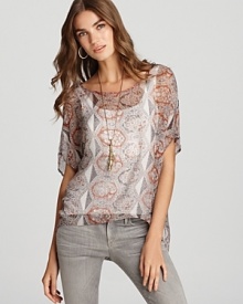 Channel modern bohemian style in this Sam & Lavi top, flaunting an eclectic print and billowy high/low hem.