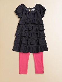 This charming two piece set for your little girl pairs a ruffled, denim tunic and boldly hued leggings with snap hem. Tunic ScoopneckShort sleeves with ruffled cuffsBack keyhole buttonRuffled hem Pants Elastic waistbandSnap hemTunic: 66% cotton/28% polyester/6% spandexLeggings: 57% cotton/38% polyester/5% spandexMachine washImported