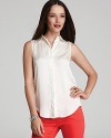 The classic white VINCE CAMUTO Plus shirt gets a warm-weather refresher with a sleek sleeveless silhouette. Let the crisp style pop against printed pants.