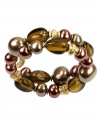 Stylishly shaped. A chic double-row coil silhouette stands out on this distinctive bracelet from Jones New York. Adorned with berry-hued plastic beads and imitation pearls, it's crafted in antique gold tone mixed metal. Approximate diameter: 2-1/2 inches.