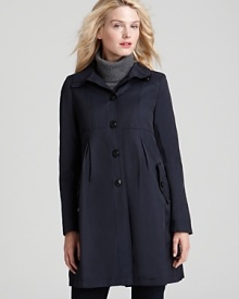 A flattering empire waist with pleating detail lets you face the rain in effortless style in this DKNY coat--complete with a detachable hood to keep you dry.