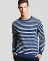 Bold blue and white stripes add Parisian flair to a classic cotton crew neck sweater from Lacoste.